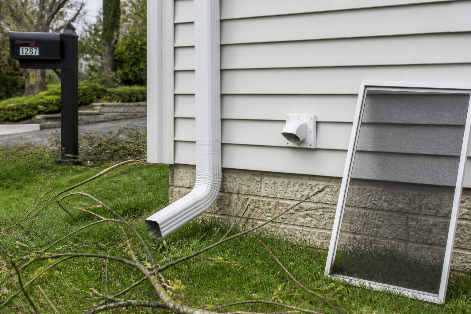 Downspout and dryer vent on a house after a storm